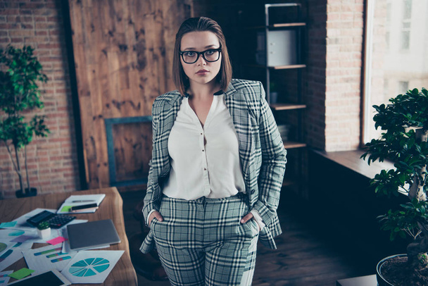 Close up photo beautiful amazing she her business busy lady eyewear eyeglasses not smiling hands arms pockets turned off notebook table stand front office wear specs formal-wear checkered plaid suit - Фото, зображення