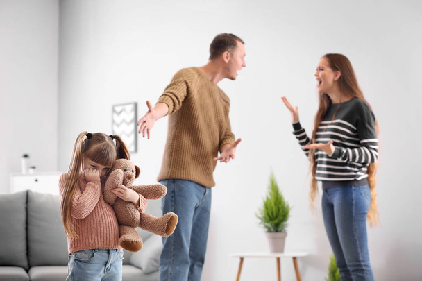 Triste bambina e i suoi genitori litiganti a casa - Foto, immagini