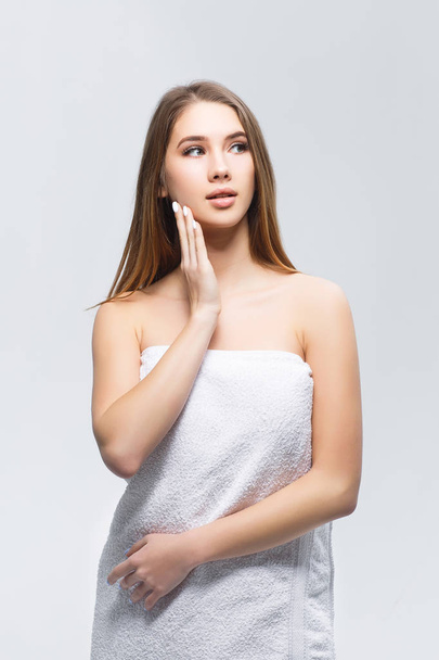 Young woman with towel on body isolated on white background - Fotó, kép