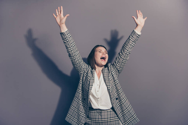 Closeup photo portrait of beautiful cheerful excited screaming with open mouth raising fists hands up isolated grey background - Фото, изображение