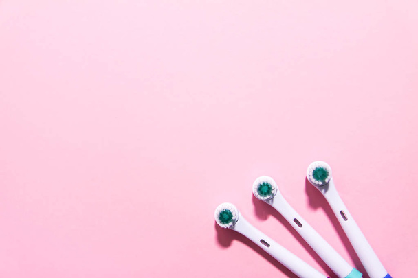 Duas escovas de dentes elétricas em um fundo rosa claro suave
 - Foto, Imagem