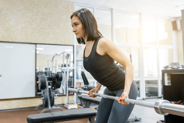 Young beautiful athletic woman brunette doing fitness exercises in the gym. Fitness, sport, training, people, healthy lifestyle concept. - 写真・画像
