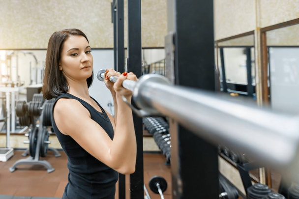 Young beautiful athletic woman brunette doing fitness exercises in the gym. Fitness, sport, training, people, healthy lifestyle concept. - Valokuva, kuva