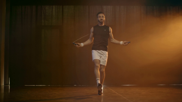 Vista completa del deportista en pantalones cortos blancos saltando con una cuerda
 - Metraje, vídeo
