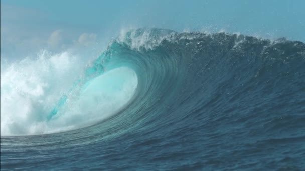 Nahaufnahme: Großartige Aufnahme einer riesigen Röhrenwelle, die in der Nähe einer abgelegenen exotischen Insel in Chile kracht. massive smaragdfarbene Tonnenwelle spritzt und sprüht Tropfen glasigen Meerwassers in den klaren blauen Himmel. - Filmmaterial, Video