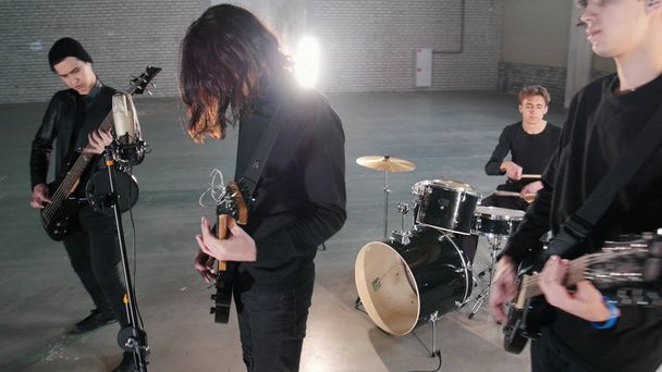 Un grupo de rock joven que tiene una repetición en un garaje. Miembros de un grupo con ropa negra
 - Foto, Imagen