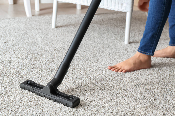 Woman hoovering carpet with vacuum cleaner - Fotografie, Obrázek