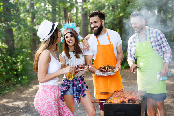 Group of friends having outdoor barbecue party and fun together - Foto, imagen