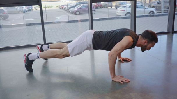 Αθλητής με λευκό σορτς κάνει push ups στο γυμναστήριο - Πλάνα, βίντεο