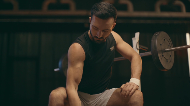 Sportivo muscoloso concentrato in pantaloncini bianchi che fa riccioli di bicipiti con manubrio
 - Filmati, video