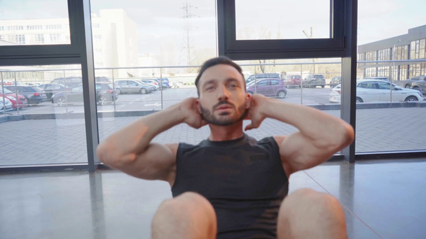 Esportista barbudo em shorts brancos fazendo abdominais no ginásio
 - Filmagem, Vídeo