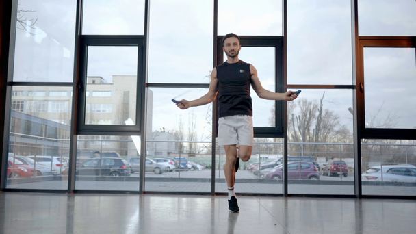 Θέα σε ολόκληρο το μήκος του αθλητή πηδώντας με σχοινί στο γυμναστήριο - Πλάνα, βίντεο