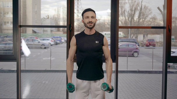 Μουσάτος αθλητής σε λευκό σορτς εκπαίδευση με βαράκια στο γυμναστήριο - Πλάνα, βίντεο