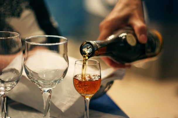 Man pours brandy into a glass, closeup photo - Foto, imagen