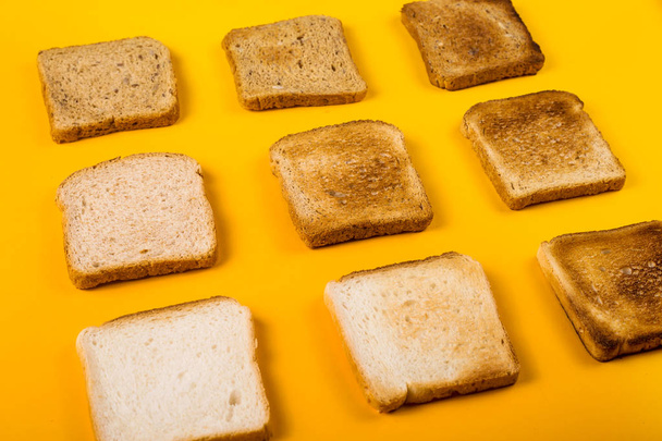 Une sélection de pain grillé pour le petit déjeuner. Minimalisme sur jaune
 - Photo, image