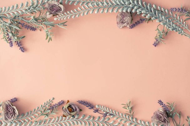 Creative layout made with spring flowers and leaves on pastel pink background. Minimal nature composition  - Fotoğraf, Görsel