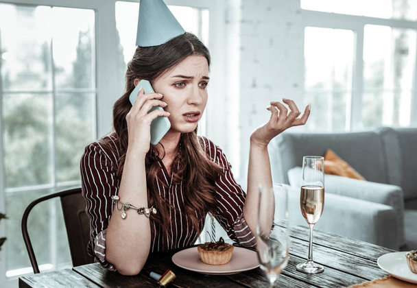 Sad woman talking on the phone on her birthday - 写真・画像