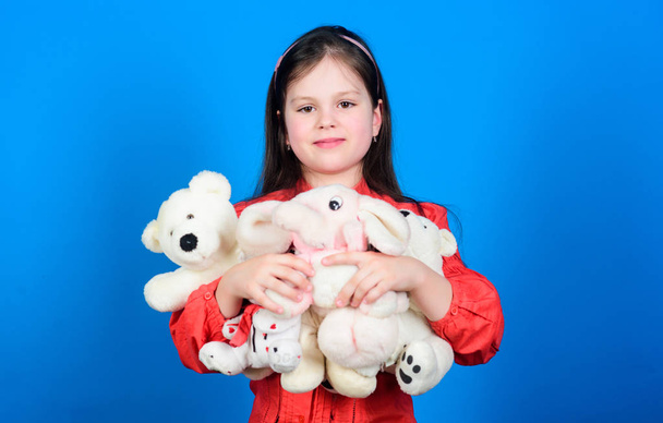 Collecting toys hobby. Cherishing memories of childhood. Childhood concept. Small girl smiling face with toys. Happy childhood. Little girl play with soft toy teddy bear. Lot of toys in her hands - Photo, Image