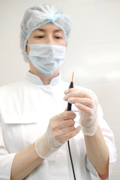 Női bőrgyógyász sebész készít professzionális Elektrokauterizáció eltávolítására anyajegy. Rádióhullám elektrokoagulációs eltávolítása módszer - Fotó, kép