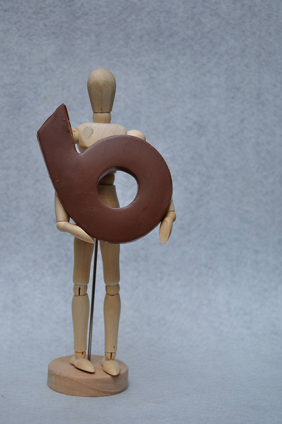A wooden art mannequin with a chocolate number six - Photo, Image