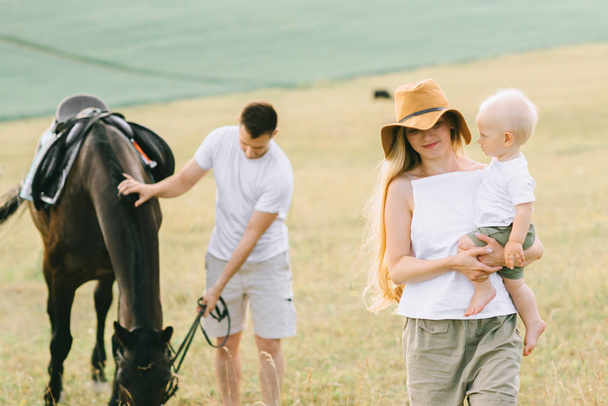 A young family have a fun in the field. Parents and child with a - Photo, Image