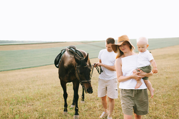 A young family have a fun in the field. Parents and child with a - Valokuva, kuva