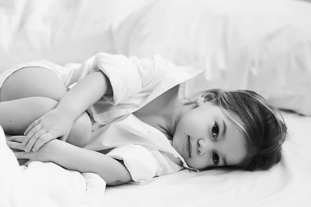 A portrait of beautiful little girl in the morning bedroom - Zdjęcie, obraz