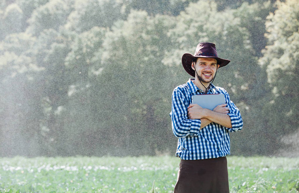 farmer man agronomist sun worker check digital tablet computer plantation technology hat sprinkler system water - Zdjęcie, obraz