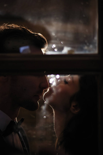 Retrato sensual de um casal apaixonado através do vidro com costas
 - Foto, Imagem