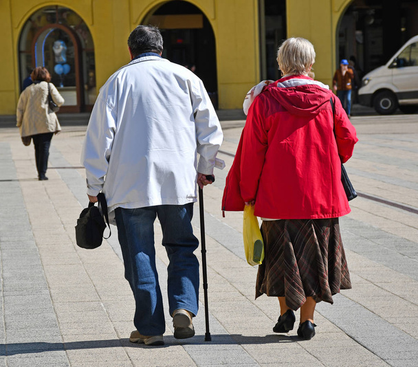 Des personnes âgées marchent dans la rue de la ville
 - Photo, image