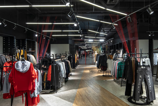 Modern clothes shop with large selection of different wear and shoes - Photo, Image