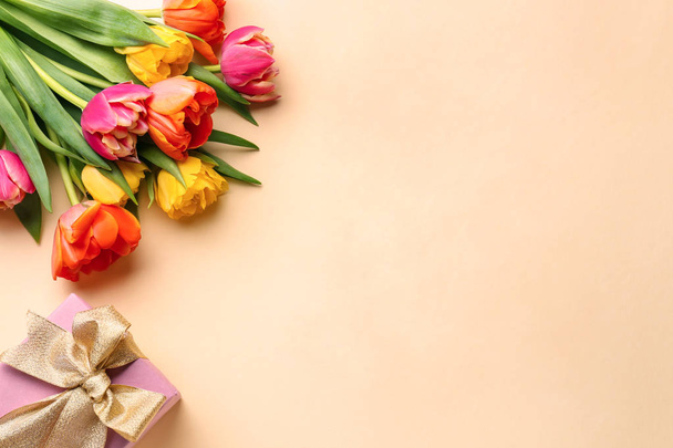 Beautiful tulip flowers with gift box on color background - Photo, Image