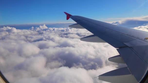 Wing of an airplane flying above the sky with clouds - Footage, Video