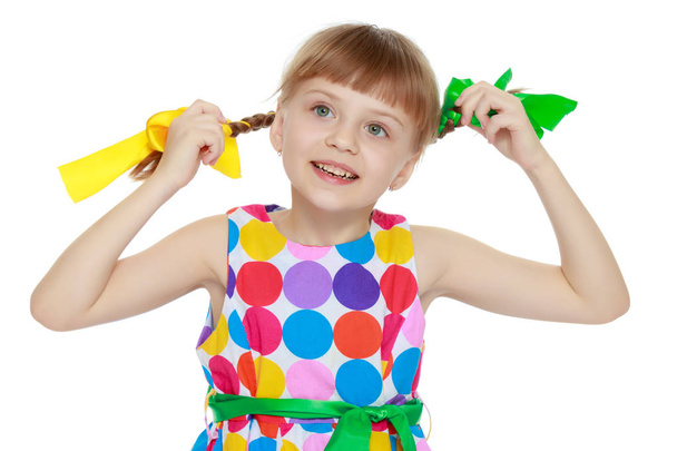Une petite fille dans une robe avec un motif de cirque multicolore
 - Photo, image