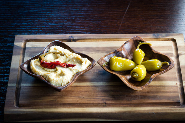 Hummus aux poivrons épicés sur assiettes en bois
 - Photo, image