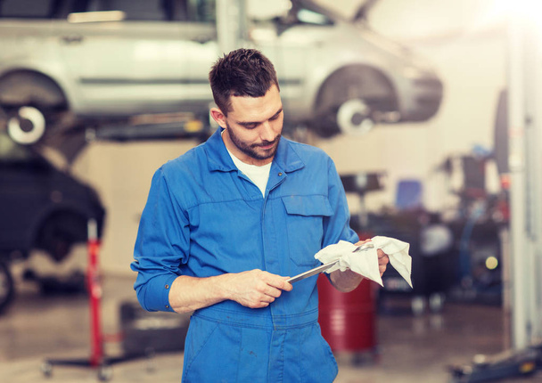 auto mechanic or smith with wrench at car workshop - Foto, imagen