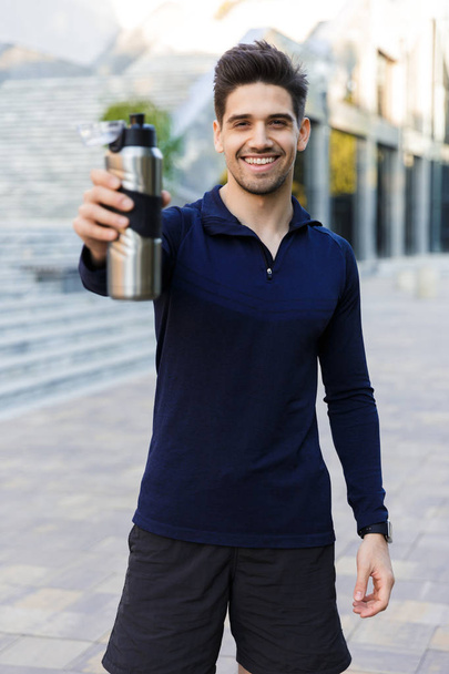 Confident young sportsman holding water bottle - Foto, Imagen