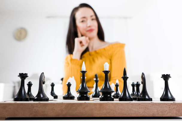 チェスの前に座っている黄色いドレスの女性-戦略 - 写真・画像
