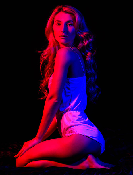 Enjoying her beauty. Blond curly hair. Pinup look. Fashion beauty. Pin up woman in bodysuit. Sensual girl with fit body in red light at night. Sexy woman in erotic lingerie. at night. night life - 写真・画像