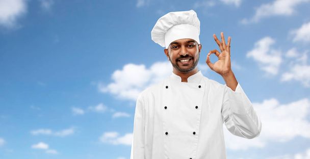 happy male indian chef in toque showing ok gesture - Foto, Bild