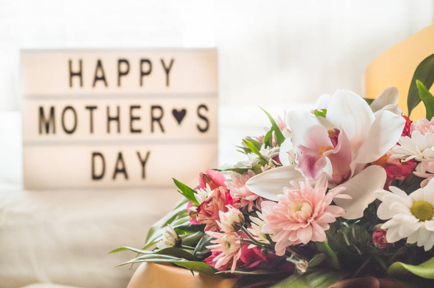 幸せな母の日。テーブルの上に熱いお茶と花の美しい花束 - 写真・画像