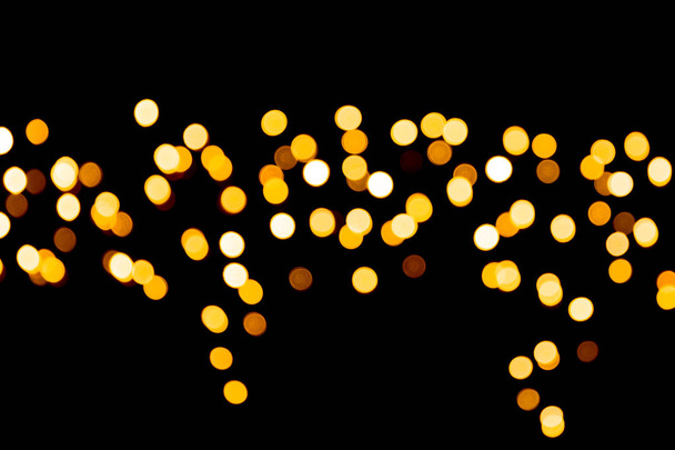 Εορταστική αφηρημένη χρυσό φόντο με bokeh defocused και θολή πολλά στρογγυλό, κίτρινο φως σε σκούρο φόντο χριστουγεννιάτικο - Φωτογραφία, εικόνα