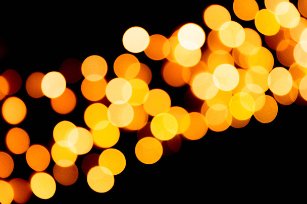 Defocused city gold night bokeh abstract background. blurred many round yellow light on dark background - Photo, Image