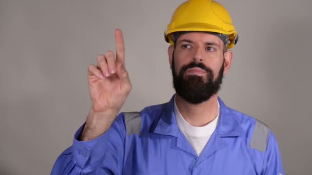 Бородатий чоловік-будівельник в шоломі готовий написати щось пальцем. Бородатий працівник з бородою в будівельному шоломі або капелюсі
 - Кадри, відео