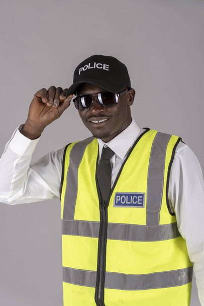  Portret uśmiechniętego policjanta w mundurze i trzymając parę ciemnych okularów. 2019 kwietnia - Zdjęcie, obraz