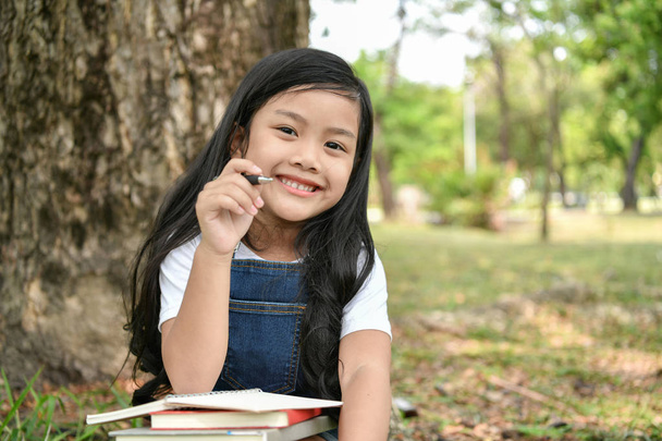 ««««Fogalmaival. A lány a kertben egy könyvet olvas. Kell - Fotó, kép