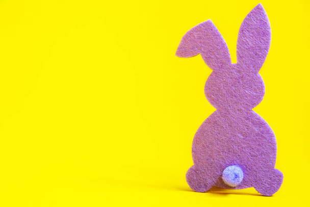 Silhouette of a lilac Easter bunny on a yellow background. - Zdjęcie, obraz