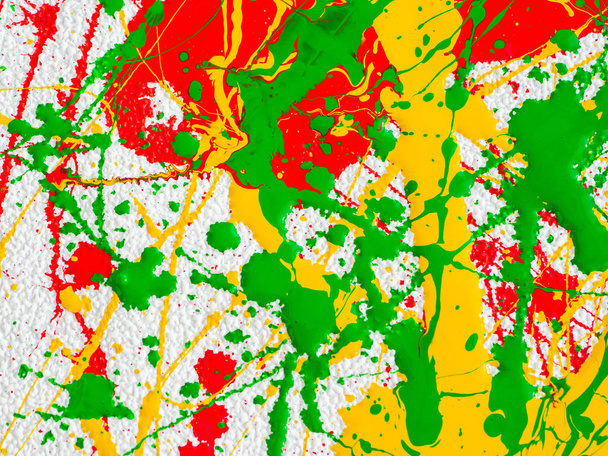 roiskeet punaista ja keltaista vihreää maalia valkoisella taustalla
 - Valokuva, kuva