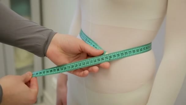 Males hands are measuring the skinny girls waist with green string. No face. A boy measuring waist to his girl with green ribbon - Footage, Video