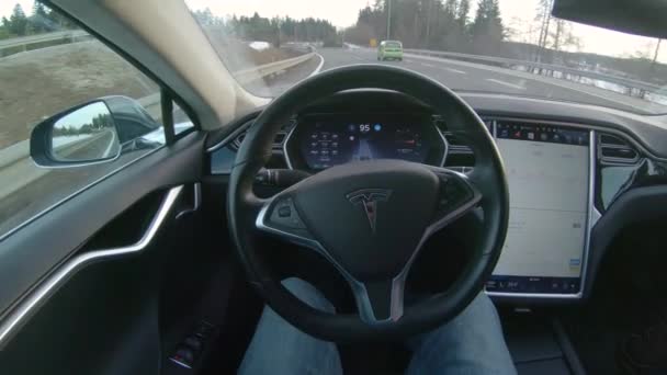 Autonomous car - FEBRUARY 1st 2017: Male driver sitting behind the steering wheel and enjoying relaxing and comfortable ride in autonomous self-driving autopilot Tesla Model S driverless car - Video